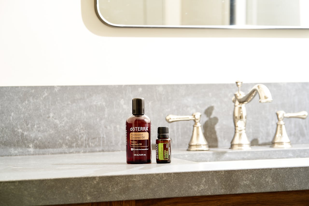 Beautiful display of essential oils on a modern bathroom countertop with a stylish faucet.