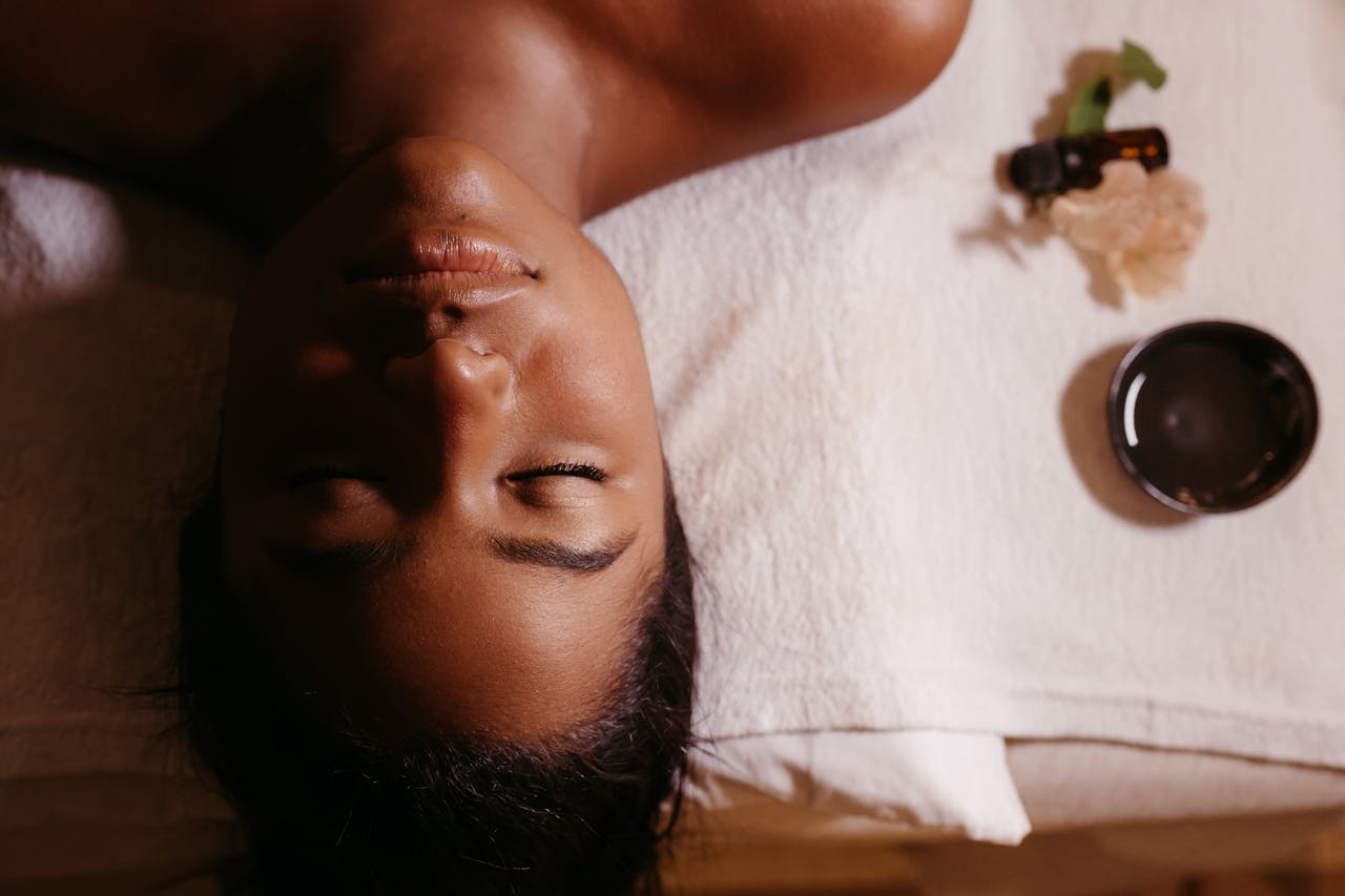 Serene spa massage with a woman relaxing and essential oils, promoting wellness and tranquility.