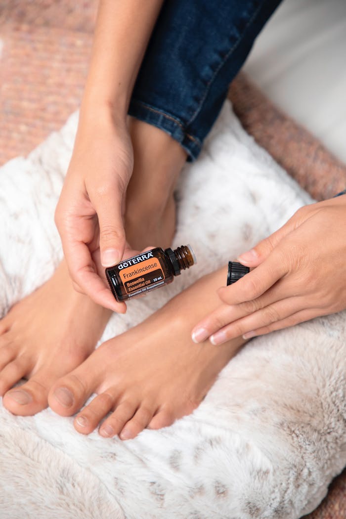 why-choose-us Hands applying essential oil treatment on feet for skincare and relaxation.