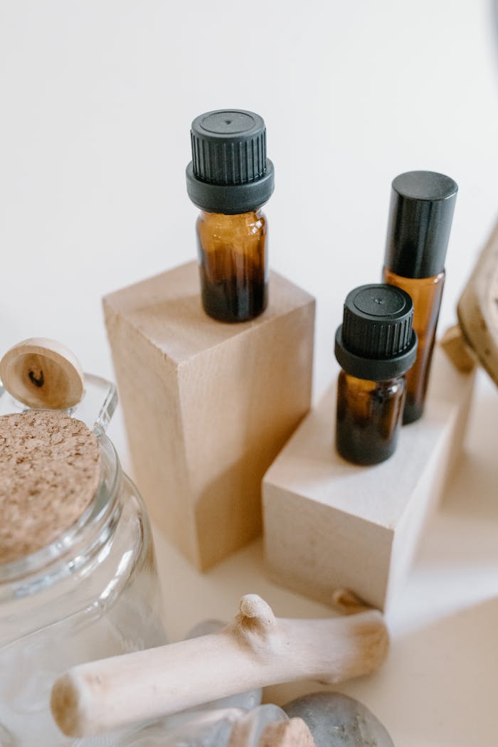 who-we-are Three essential oil bottles on display with wooden blocks, perfect for aromatherapy or home decor.